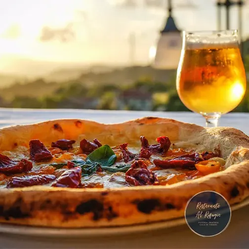pizza al tavolo con birra e vista panoramica